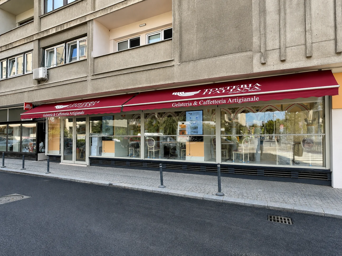 Copertine retractabile clasice roșii montate pe fațada unei gelaterii