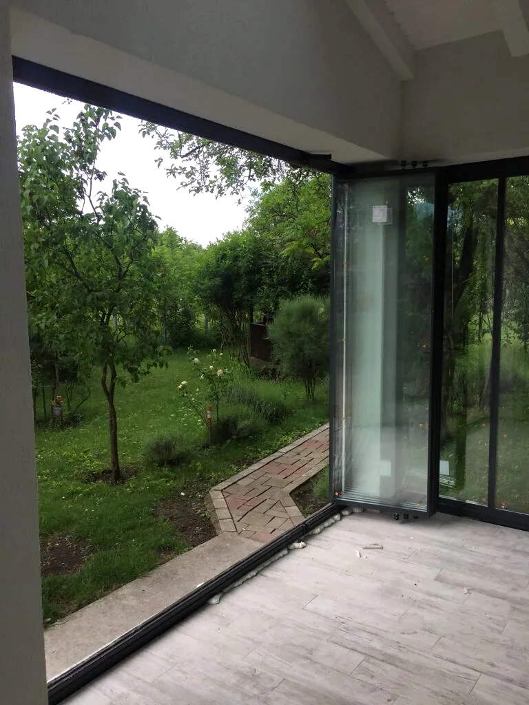 Panouri de sticlă strânse lateral și deschidere liberă spre grădină, Cornu, Prahova