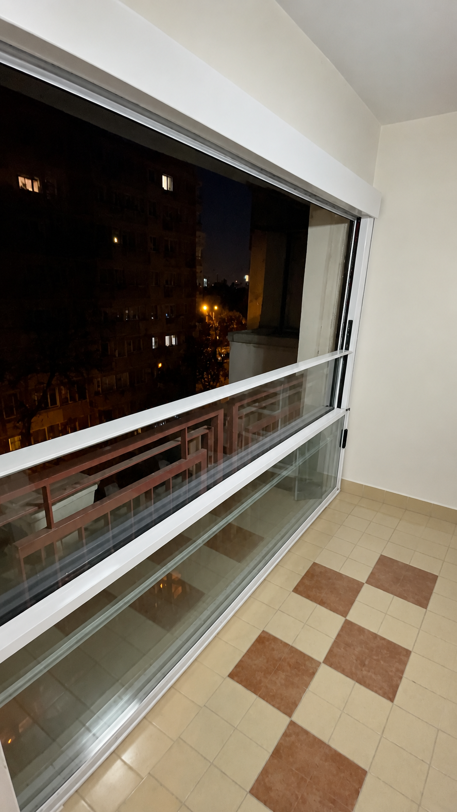 Vedere din interior, pe timp de noapte, a sistemului de sticlă ghilotină cu profile albe din București, Sectorul 1.