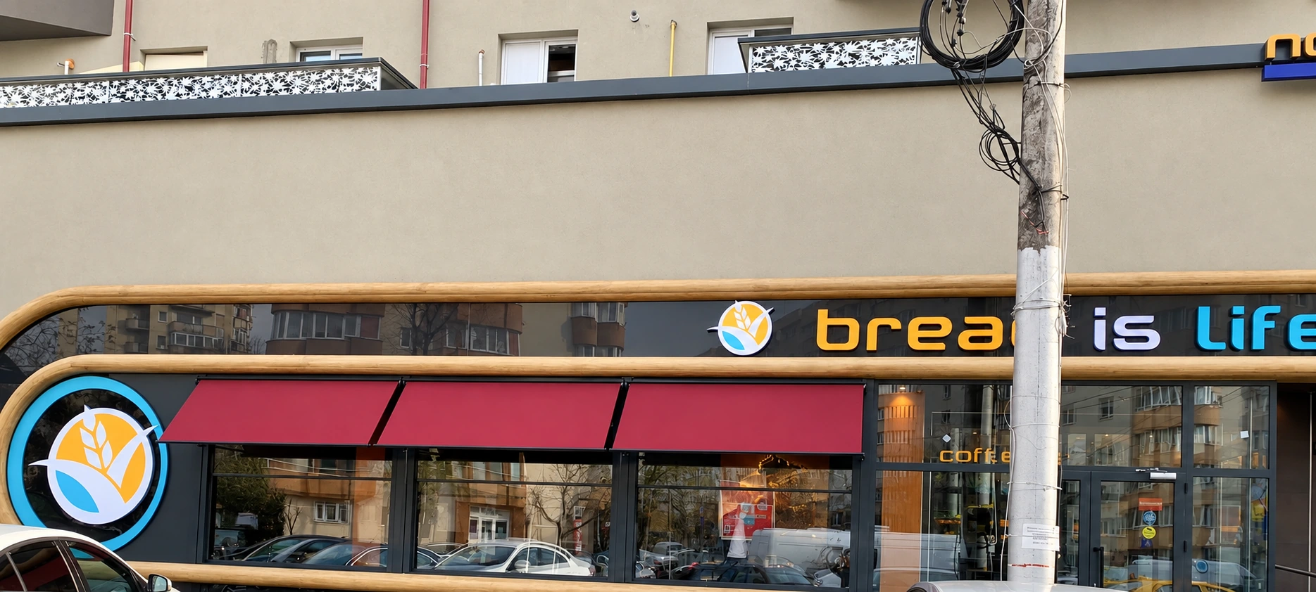 Vedere frontală a celor trei copertine bordo montate pe fațada brutăriei Koksal din Vitan.
