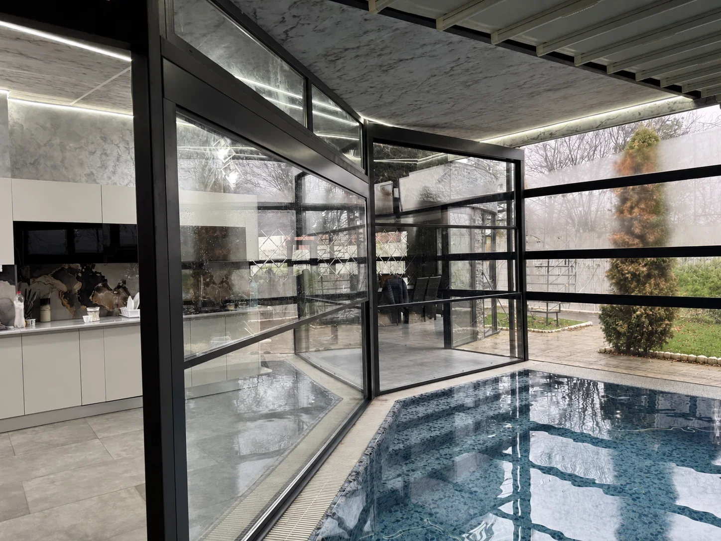 Detaliu de colț al închiderii vitrate din zona piscinei din Potigrafu.