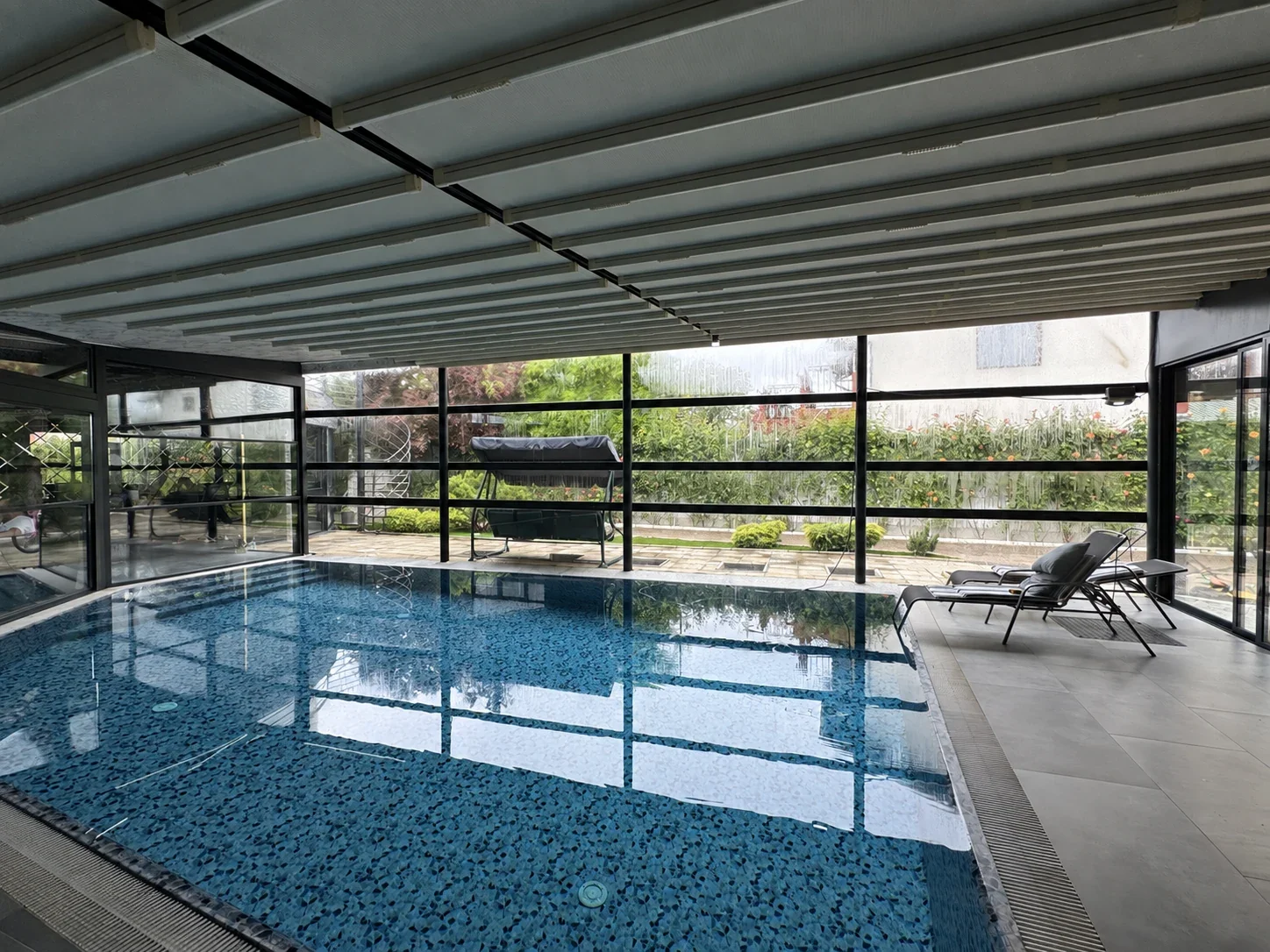 Vedere de ansamblu a piscinei și pergolelor retractabile din Potigrafu.