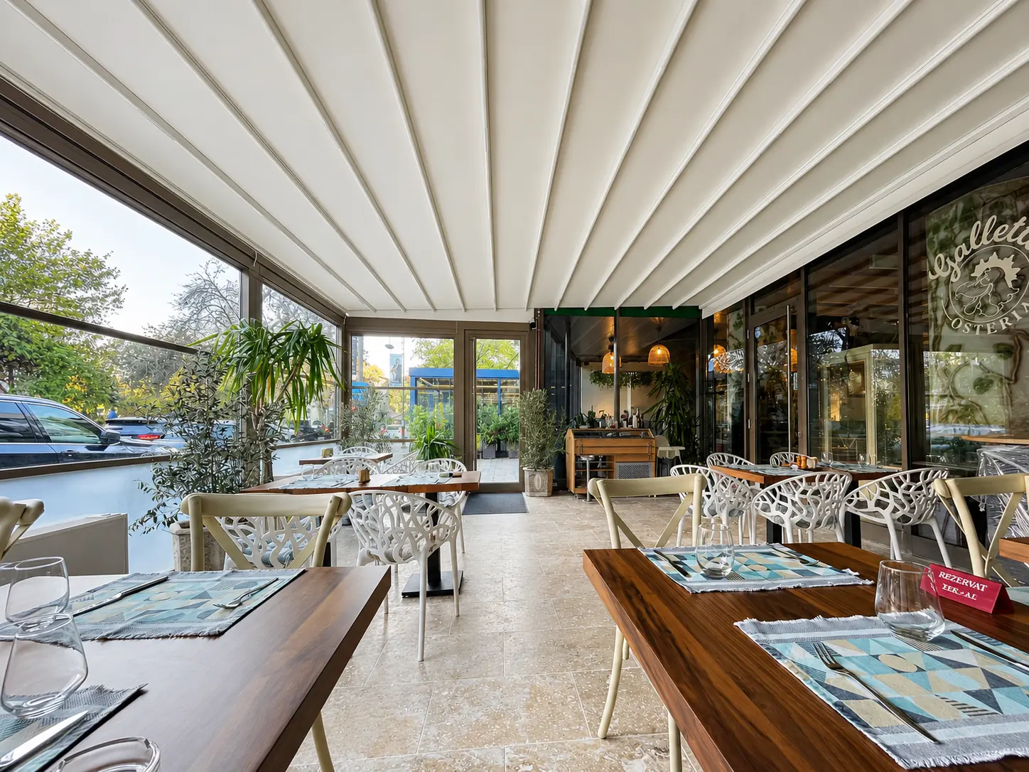 Interiorul terasei Osteria Galletto protejat cu pergolă retractabilă și sticlă