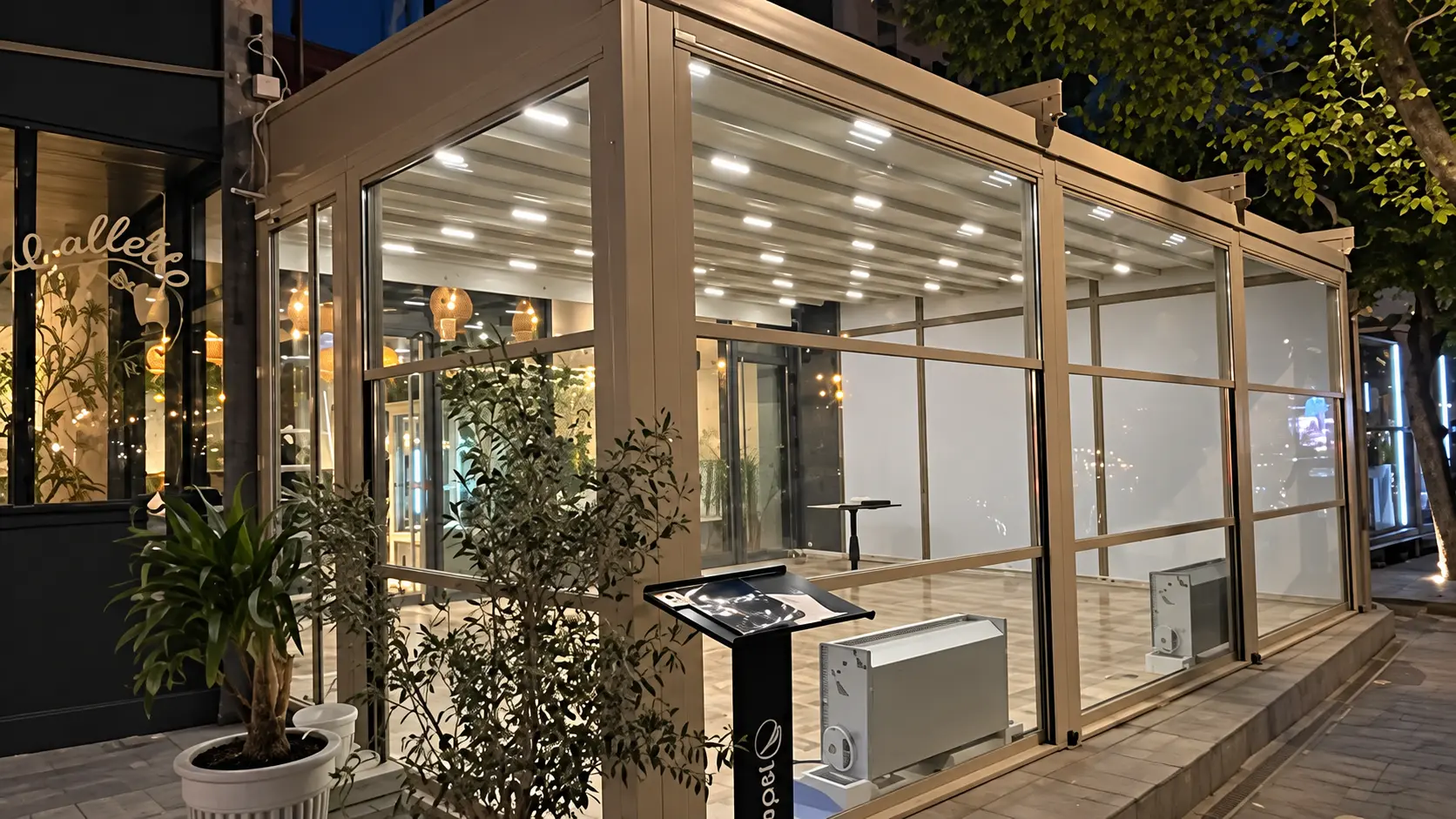 Sisteme ghilotină și pergolă iluminată seara la un restaurant din București