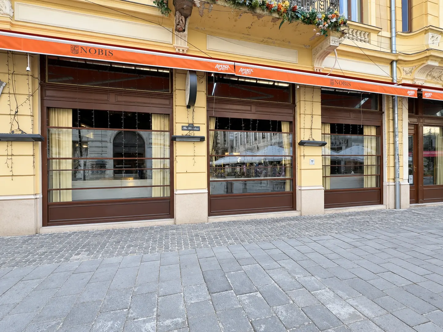 Fațada Nobis Bar cu sisteme ghilotină din sticlă montate între golurile existente